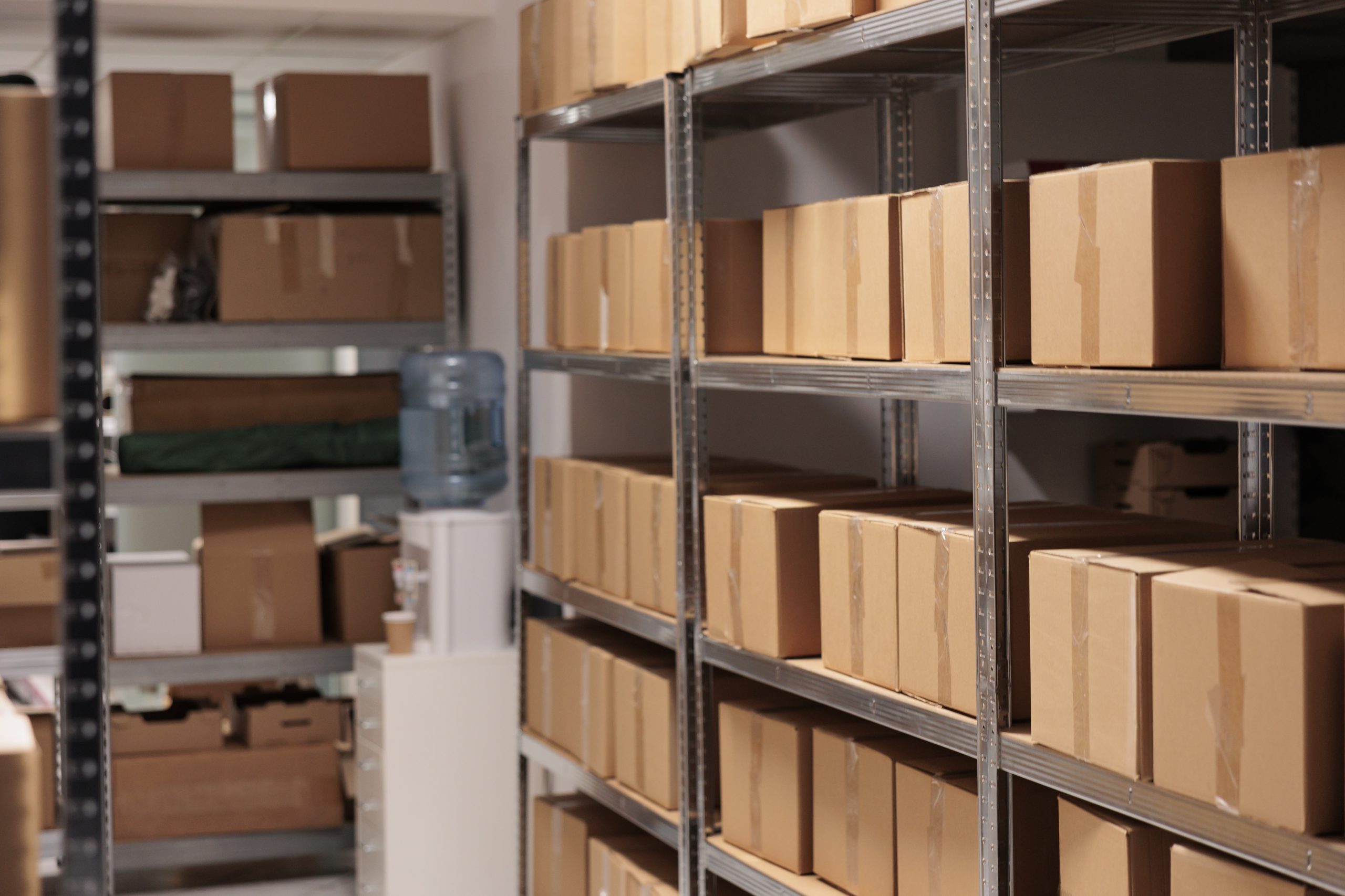 Customer order boxes on shelves in delivery service warehouse ready for shipment. Cardboard containers stacked on racks in factory export distribution department storehouse